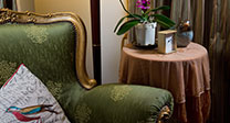 Chair, lamp and side table with clock and orchids